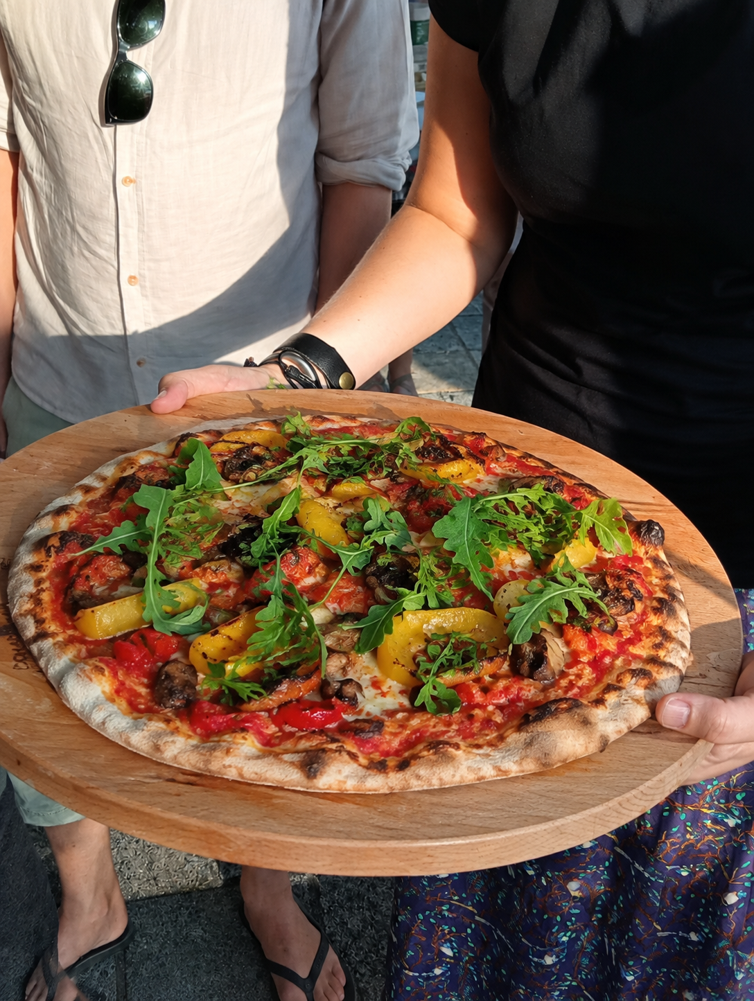 Verse houtovenpizza met gegrilde groenten op een houten plank
